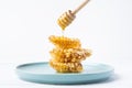 Golden Harmony: Three Honeycombs on a Blue Plate with Drizzling Honey
