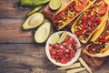 Three Mexican tacos with minced beef and mix vegetables on old rustic table. Mexican dish with sauces salsa in bowl and avocado. S Royalty Free Stock Photo