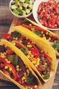 Three Mexican tacos with minced beef and mix vegetables on old rustic table. Mexican dish with sauces salsa in bowl and avocado. S Royalty Free Stock Photo