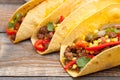 Three Mexican tacos with minced beef and mix vegetables on old rustic table. Mexican dish with sauces salsa in bowl and avocado. S Royalty Free Stock Photo