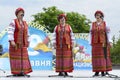 Three middle-aged women in Ukrainian traditional embroidery costumes singing during concert devoted to the Remembrance Day