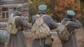 Three military men with big bags on their back are shooting.