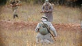 Three military men are going near the trench with guns