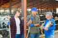 Milk farm workers talking in cowhouse Royalty Free Stock Photo