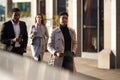 Three millennial city workers walking in a London street, selective focus