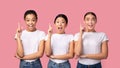 Three Millennial Girls Pointing Finger Up Standing, Pink Background, Panorama