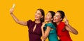Three Millennial Girls Using Phone Making Selfie, Studio Shot, Panorama