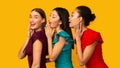 Three Millennial Girls Whispering Secrets, Yellow Background, Panorama Royalty Free Stock Photo