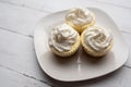 Three mini Cheesecakes with whipped cream icing on a white plate Royalty Free Stock Photo