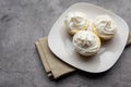 Three mini Cheesecakes with whipped cream icing on a white plate Royalty Free Stock Photo