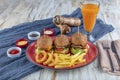 Three different burger with pickles onion rings and french fries on red plate with copy space, top view Royalty Free Stock Photo