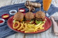 Three different burger with pickles onion rings and french fries on red plate with copy space, top view Royalty Free Stock Photo
