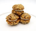 Three mini oatmeal whoopie pie cookies stacked on a plate