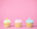 Three mini cupcakes on pink copy space