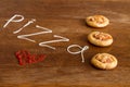 Three mini pizzas with sausage and cheese on wood table Royalty Free Stock Photo