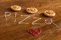 Three mini pizzas with sausage and cheese on wood table Royalty Free Stock Photo