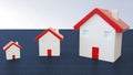 Three miniature houses with red roof on wooden blue background