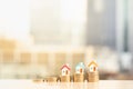 Three miniature houses on stack of coins on modern city background Royalty Free Stock Photo