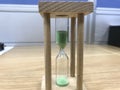 A three minutes Green color sand glass timer is active for an meeting time as a deadline for an task to an employee to complete Royalty Free Stock Photo