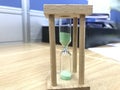 A three minutes Green color sand glass timer is active for an meeting time as a deadline for an task to an employee to complete Royalty Free Stock Photo