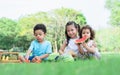 Three mixed race caucasian little cute children kids sitting, playing in outdoor green park for picnic, eating fruit, watermelon Royalty Free Stock Photo