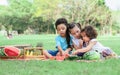 Three mixed race caucasian little cute children kids sitting, playing in outdoor green park for picnic, eating fruit, watermelon Royalty Free Stock Photo