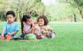 Three mixed race caucasian little cute children kids sitting, playing in outdoor green park for picnic, eating fruit, watermelon Royalty Free Stock Photo