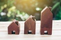 Three model houses placed on wooden floor. planning savings money of coins to buy a home