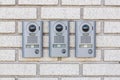 Three modern intercom on white wall near entrance to the house, space for text Royalty Free Stock Photo