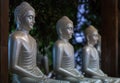 3 silver Buddhas in a lotus pose.