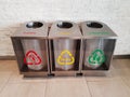 Three modern stainless trashcans on floor Royalty Free Stock Photo
