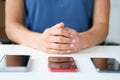 Three modern touchscreen smartphones lie on table woman with folded arms