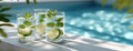 Three mojitos sit on a poolside edge, reflecting light with fresh mint and lime, embodying a peaceful, minimalist vibe in natural Royalty Free Stock Photo