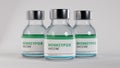 Three Monkeypox vaccine bottled medicines standing on background.