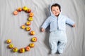 Three month old baby. three month old baby, on a gray background. laid out the figure three of apples Royalty Free Stock Photo