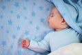 Three month old baby sleeping on blue blanket Royalty Free Stock Photo