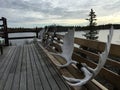 Three moose antlers attached to a wooden bench on a wooden deck of a lake house. Yellowknife, Canada Royalty Free Stock Photo