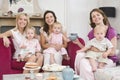 Three mothers in room with babies and coffee