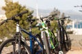 Three mountain bikes standing leaned on a wall, blue green and black one. Friends having a day of activity in the nature, resting