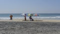 Three beach umbrellas, blue sky and ocean.