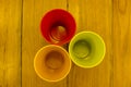 Three multi-colored glasses on a wooden table top view