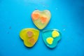 Three multi-colored handmade soaps in the form of a heart on a blue background Royalty Free Stock Photo