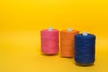 Three multi-colored spools of thread stand one after anothe Royalty Free Stock Photo