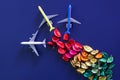 Three multi-colored toy airplanes with contrails made from multi-colored flower petals. Concept of eco-friendly biofuel and green