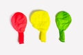 Three multi-colored uninflated balloons on a white background Royalty Free Stock Photo