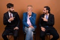 Three multi ethnic bearded businessmen together against brown background Royalty Free Stock Photo