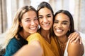 Three multi ethnic young female friends laughing together taking selfie outdoors Royalty Free Stock Photo