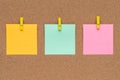 Three multicolor sticky notes on cork bulletin board, reminder important information. Blank square paper, modern template, frame.