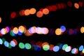 Three multicolored garlands, defocused bokeh lights on an isolated black background. Abstract magic background with Royalty Free Stock Photo