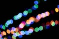 Three multicolored garlands, defocused bokeh lights on an isolated black background. Abstract magic background with Royalty Free Stock Photo